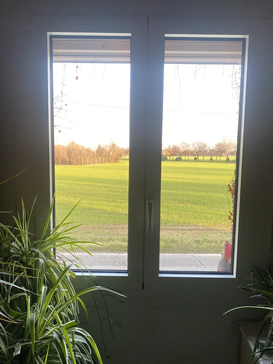 Finestra in alluminio a taglio termico installata da IS Metal srl a Teramo - vista interna con luce naturale e veduta verde