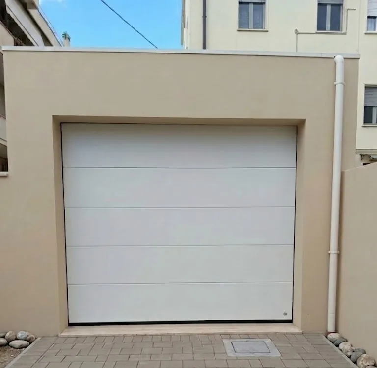 Portone sezionale per garage bianco motorizzato installato da IS Metal srl a Teramo